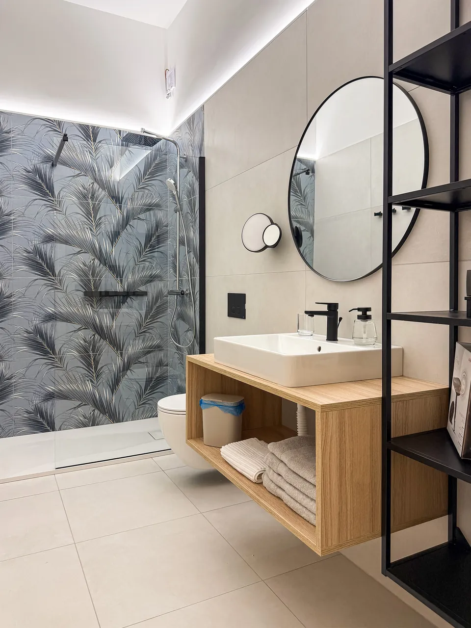 Badezimmer der Casa Tramonto mit Dusche, Holzwaschtisch und rundem Spiegel