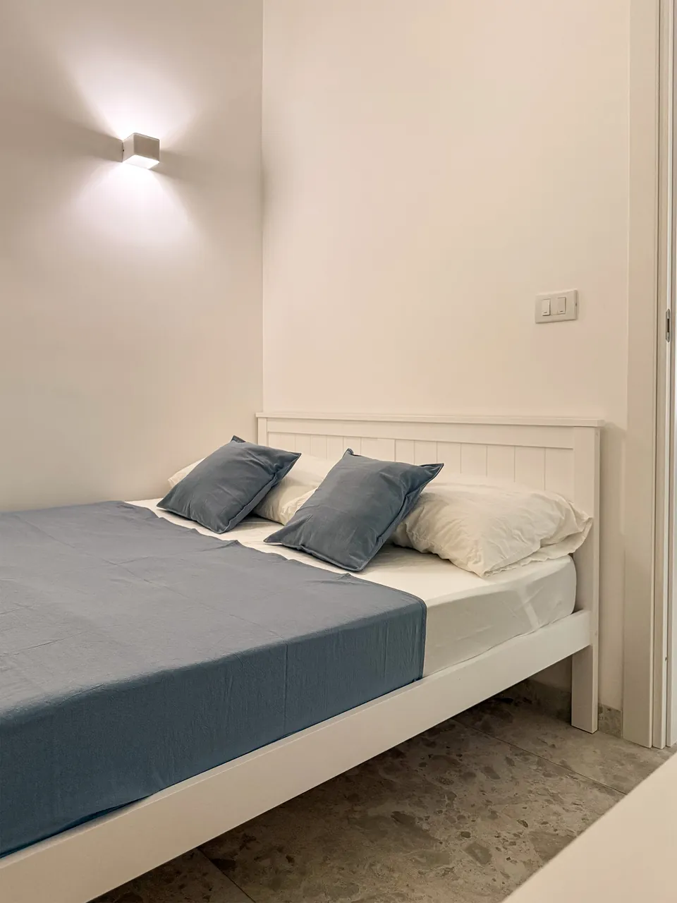 Französisches Bett mit blauer Tagesdecke im zweiten Schlafzimmer