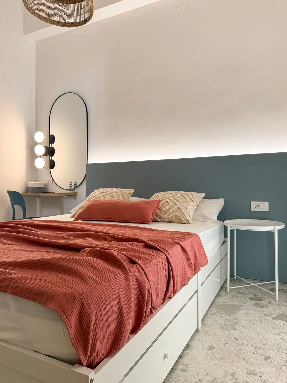 Doppelbett mit roter Tagesdecke und Frisiertisch in der Casa Tramonto