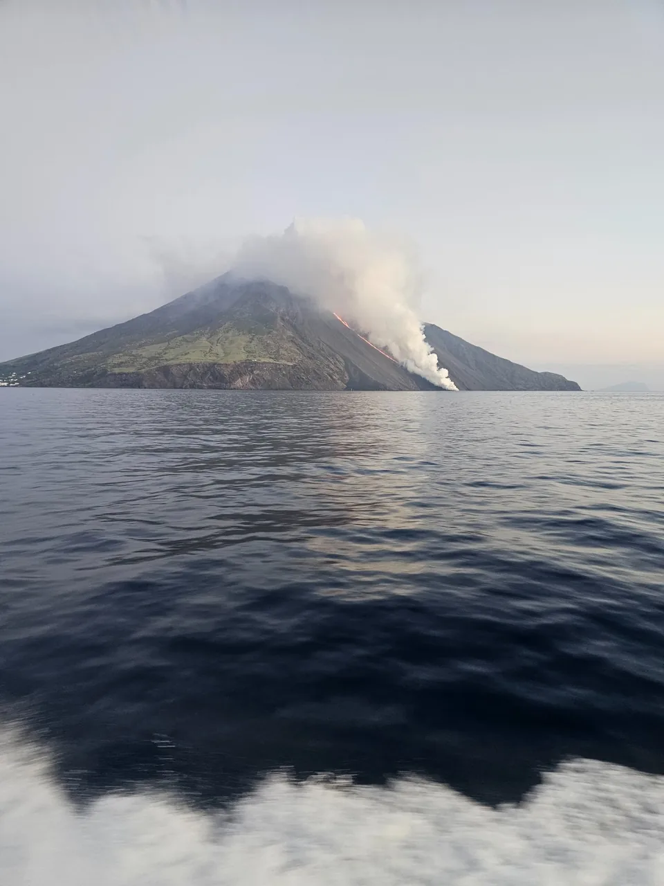 Vulkan Stromboli mit Rauchfahne, vom Meer aus gesehen