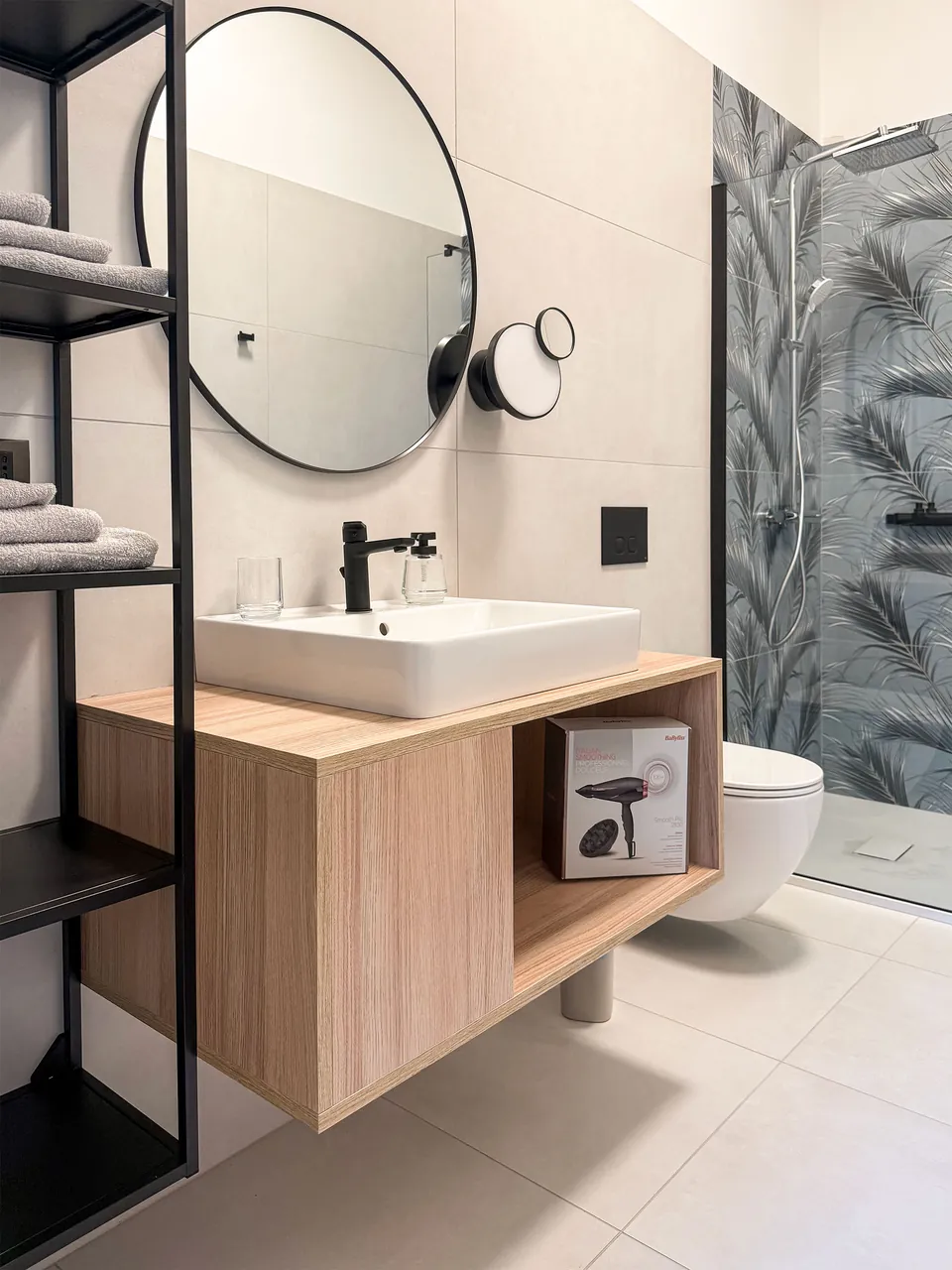 Badezimmer im Studio Alba mit Waschtisch, rundem Spiegel und Dusche